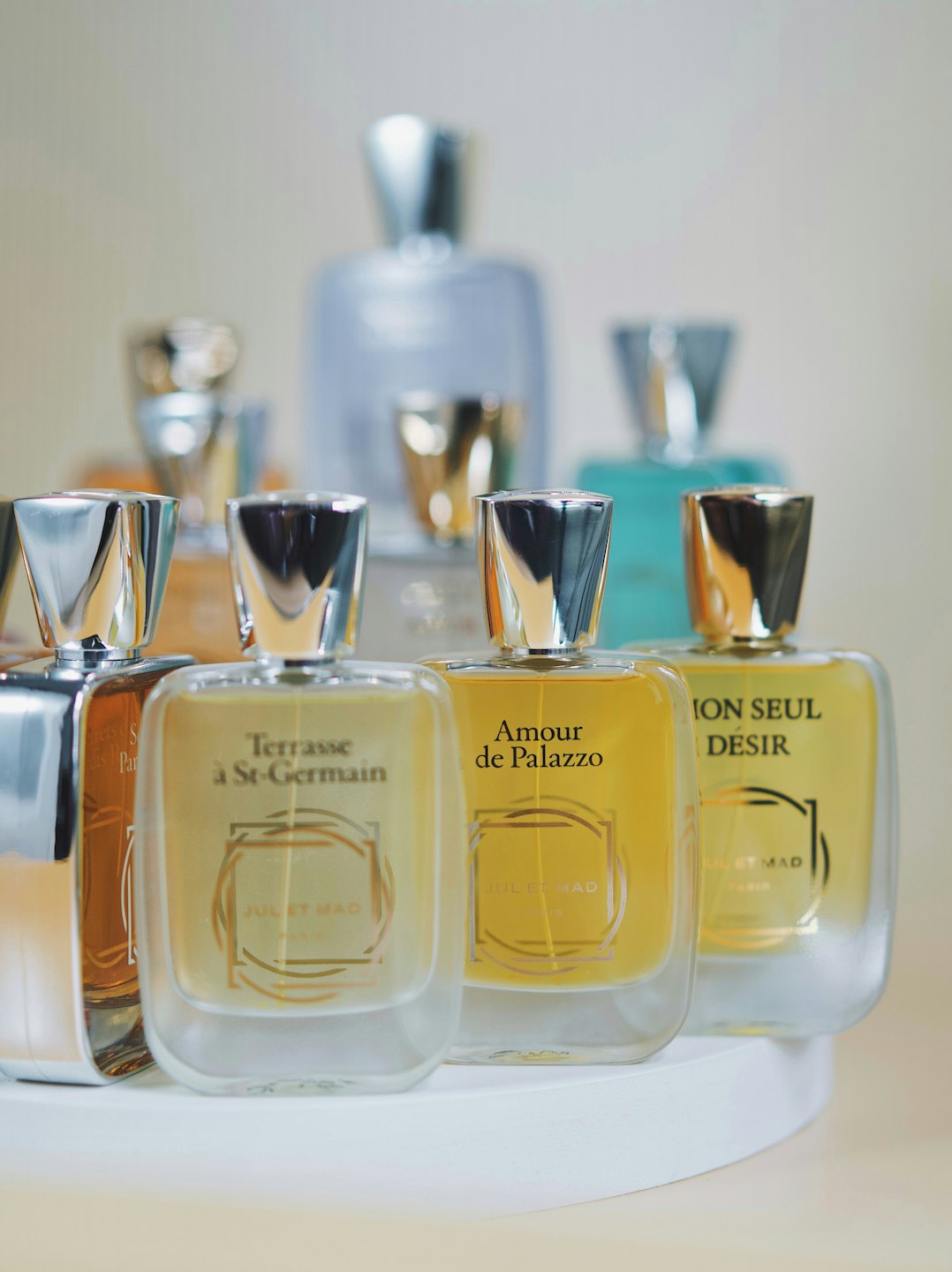 Flaconi di profumo di lusso disposti su un espositore bianco.